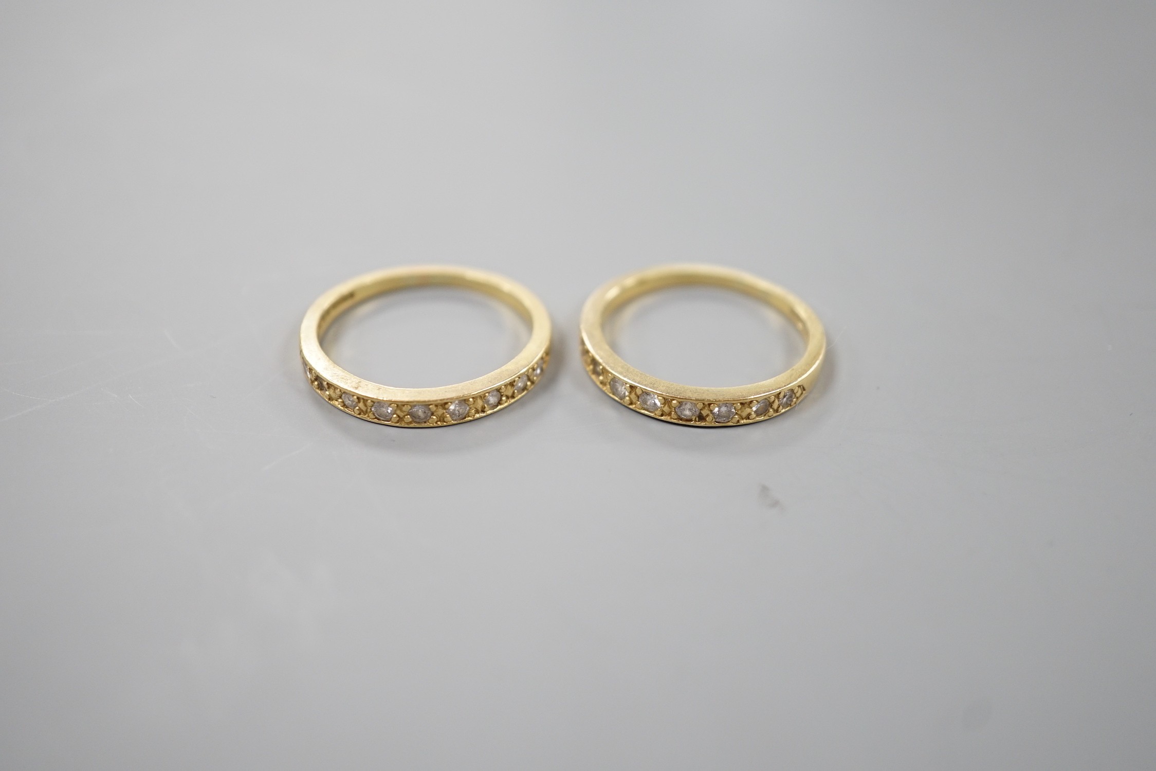A modern pair of 18ct gold and diamond set half eternity rings, size P, gross weight 5.9 grams.